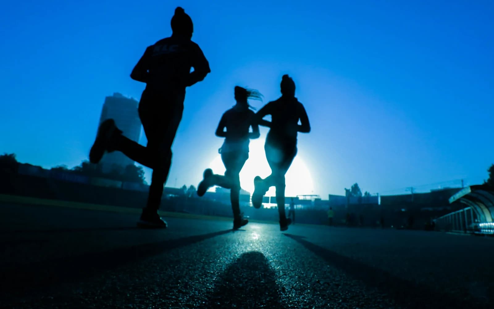 A group of people running together at sunrise